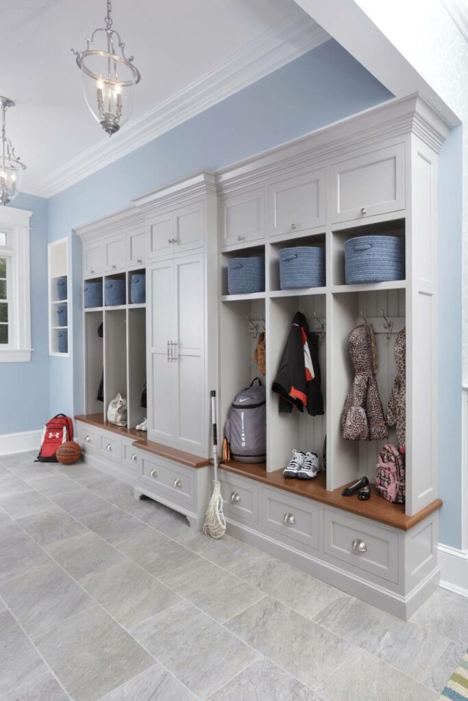 Entryway fitted with custom-built cabinet storage, featuring coat hooks, shelving, and drawers for an organized welcome area.