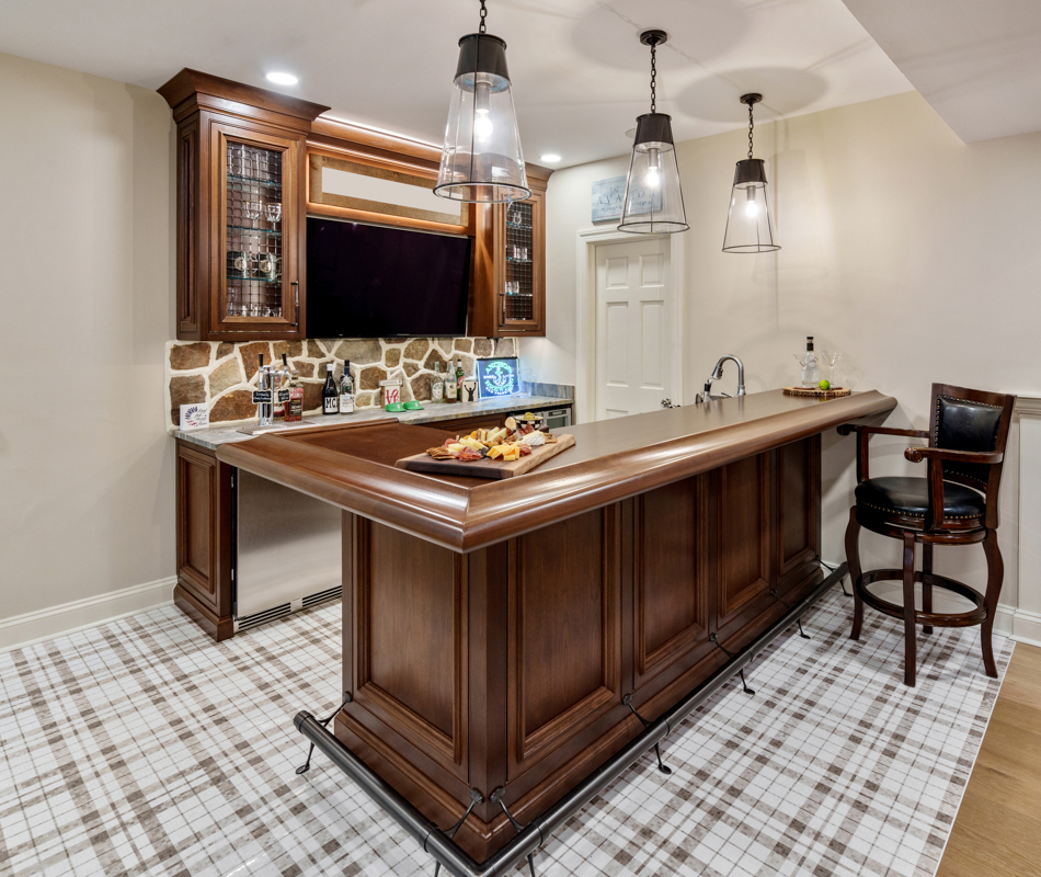 Home bar design in a classic style featuring luxury custom cabinetry in walnut wood with elegant glass accents and pendant lighting, creating a refined entertaining space.
