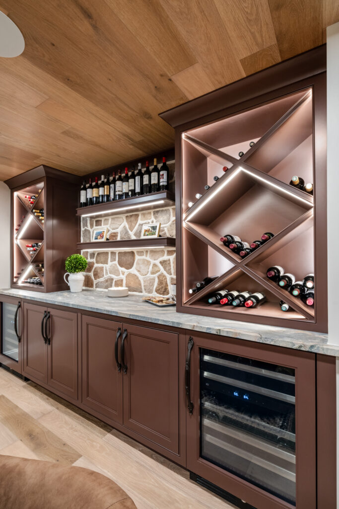 Elegant wine storage showcasing luxury custom cabinetry with a distinctive X-shaped design and mood lighting, complemented by a stone wall.