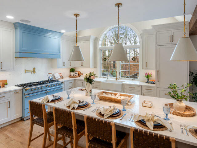 Bright and spacious kitchen featuring luxury custom cabinetry with blue accents and marble countertops, designed by Don Wall for Master Design Cabinetry.